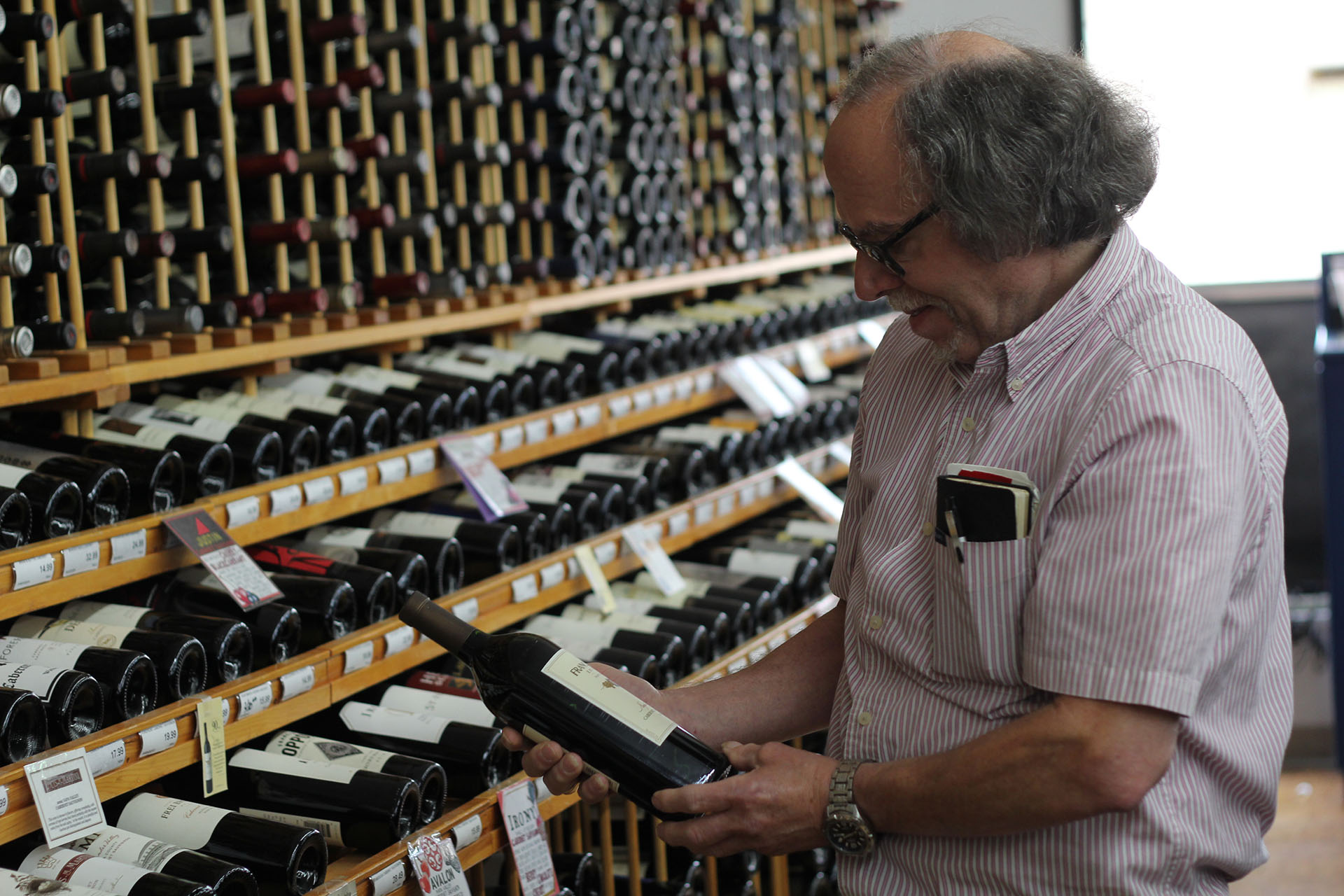 Owner of Barry's Fine Wine & Spirits Looking at Wine